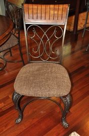 Dining chairs are black iron legs with iron and wood backs. Chair seat is brown and gold tone  20"w x 40"h x 21"d