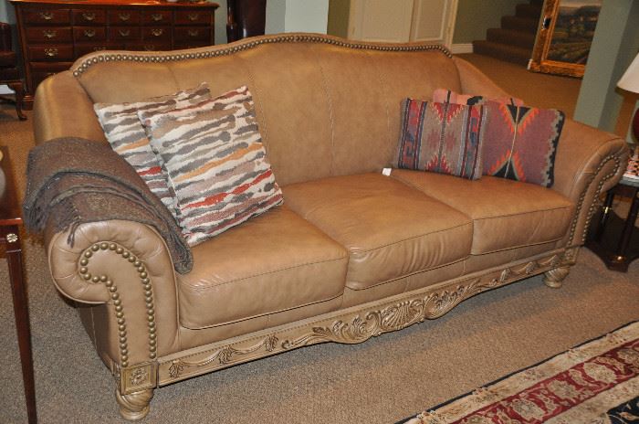 92" Carmel leather sofa with carved wood and nailhead design by Ashley Furniture in pristine condition