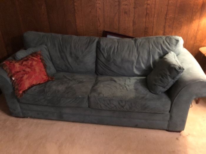Blue plush couch with lots of other furniture