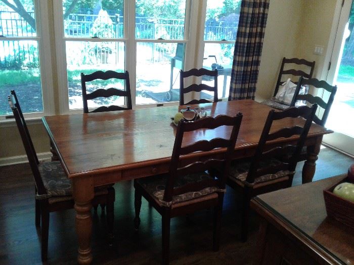 Large rustic dining table with eight chairs and two leaves