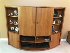 Such a cool unusual piece!  This is a curved front  Mid Century Teak entertainment center.  All four curved cabinet fronts close.  See other pictures for different looks.  