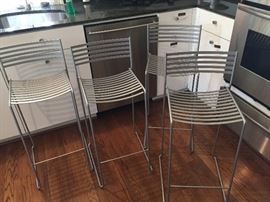 Set of four stainless steel bar stools.