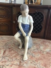 Bing and Grondahl #1757 - Boy Rolling Up Pant Leg Sitting On Stone
