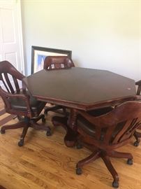 Game table with rolling swivel chairs with leather seats