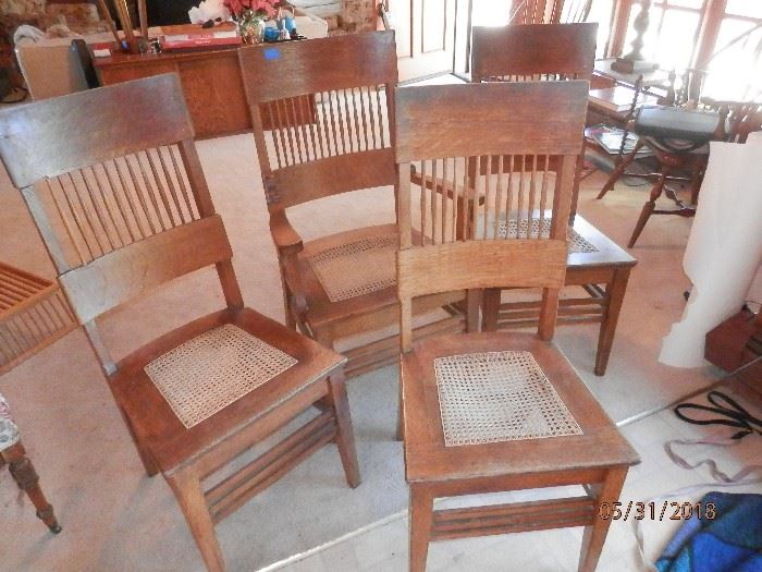 4 "Solid Oak"  Arts and craft dining chairs...spindle back and cane seats....one is an arm chair....possibly Stickley