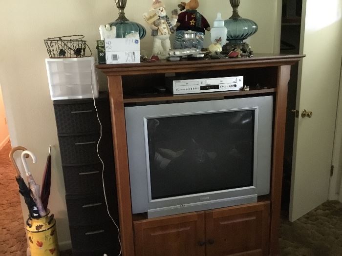 Tv, Tv cabinet, storage items, painted milk can, umbrellas