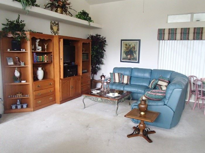 living room: teal sectional, wall unit 