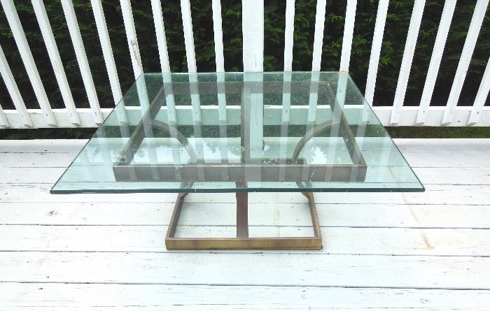 Square outdoor coffee table on brass base.
