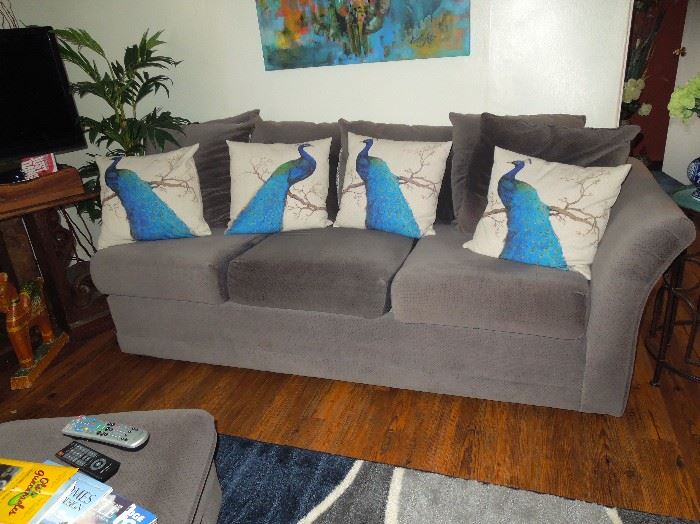 Two grey couches. Peacock throw pillows sold separately.