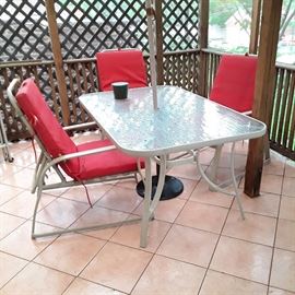 Glass top patio table 38" x 60" and six reclining chairs with pads, two ottomans