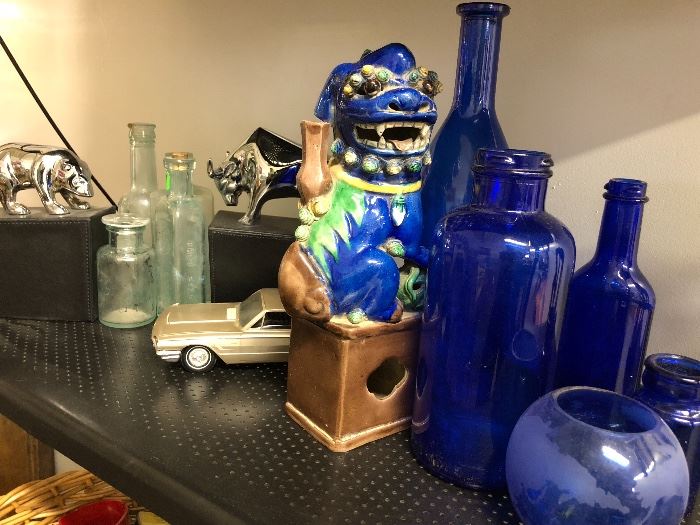 This foo dog looks right at home with these blue bottles