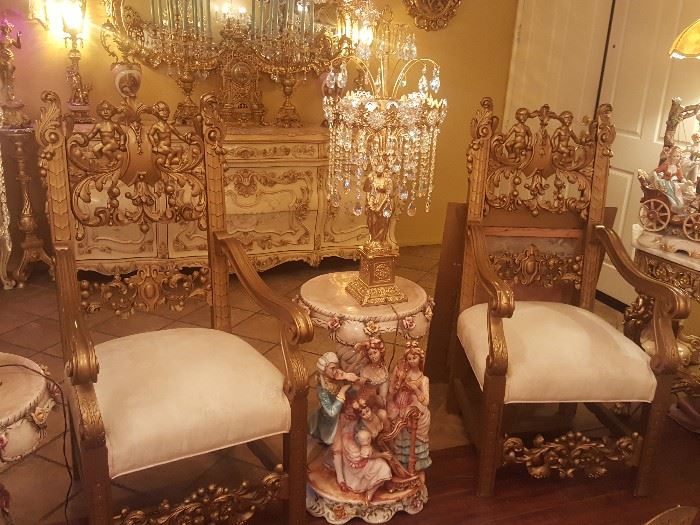 A pair of two French Rococo Throne chairs with cherubs carved into it with cherry print upholstery