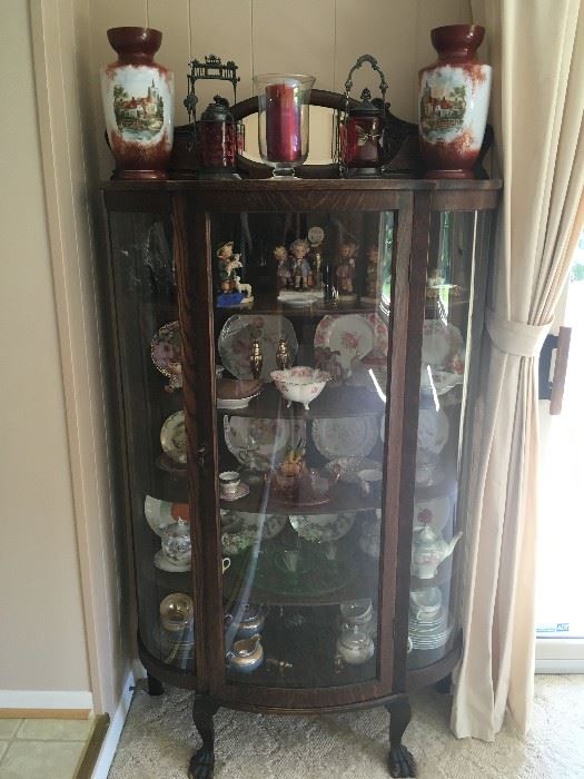 I love this early 1900's oak curved-glass china cabinet with claw feet filled with beautiful pieces/collectibles -- notice the wonderful matching vases!