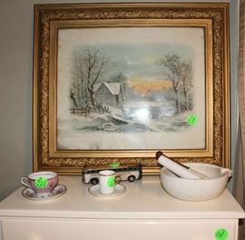 A old picture on top of white chest in craft room.