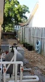 The side yard with potting bench at end and holds all the swimming pool equipment.