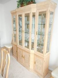Lighted display cabinet with mirrored back and glass shelves. Narrow profile cabinet is 18" deep