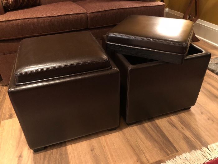 Two Crate & Barrel leather storage ottomans with wood tone reverse