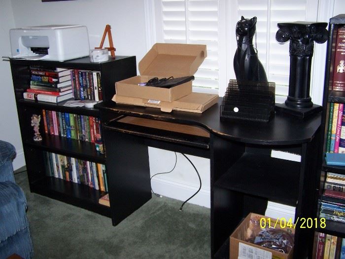 right section is a small Black Desk, Bookcase on left, Printer, ceramic Cat, Pedestal, 2 Keyboards in boxes