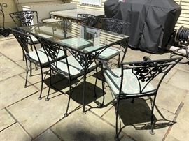 Vintage wrought iron, glass top table with matching chairs.