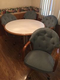 Kitchen table 4 roll around chairs.
