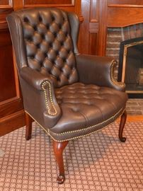 One of a pair of leather wing back chairs