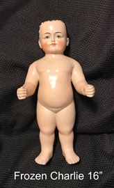 Antique German China Pink Tinted 16" Frozen Charlie Doll.  Frozen Charlie dolls were made in German by various firms between the 1850s to the early 1900s. This Charlie stands 16" tall and his body is pink tinted with dark hair. 