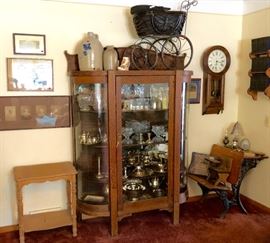Curved glass oak china cabinet filled with glass & silver-plate