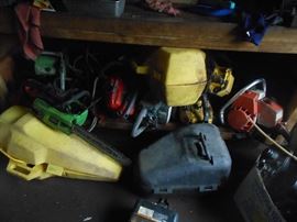 Numerous chain saws in various stages of needing repair