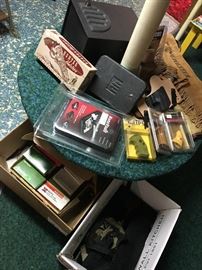  Variety of gun accessories and equipment including cases, holsters, grips, lockboxes/safes - and more - many brand new in original packaging; Lots of empty bullet casings / shells for reloading or craft projects.