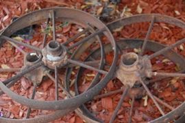 Yard art including iron wheels, concrete bulldog, vintage water pump, wishing well and more