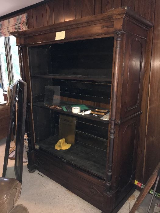 Antique armoire. Doors are leaning against it. 