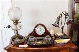 Antique Kerosene Lamp: $120.00. Crystal Votive: $12.00. Brass Nuevo Ink Well: $60.00. Mantle Clock: $30.00. Inlaid Desk Set: $90.00. Milli Fiori Lily Lamp: $60.00. Oval Noritake: $8.00 