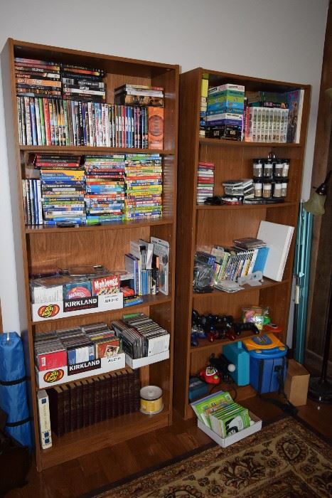 Shelving unit, VHS tapes, DVDs, video game remotes, books 