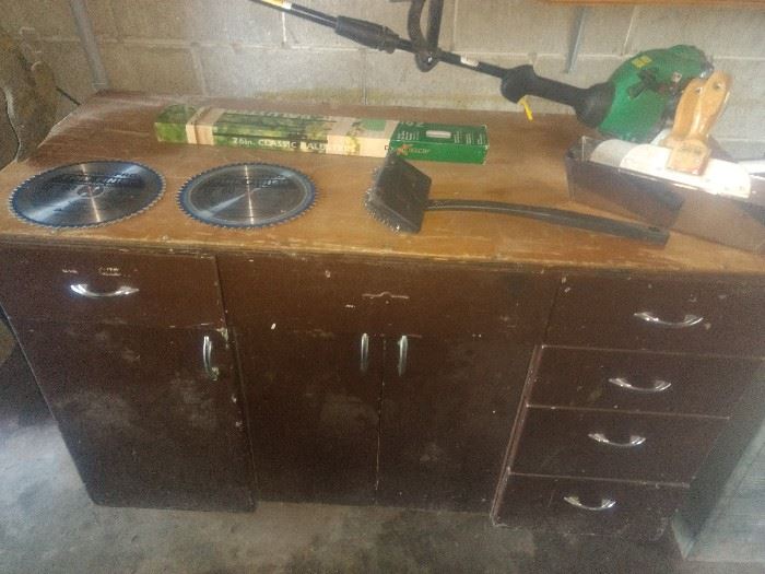 work cabinet in garage , weed eater and saw blades