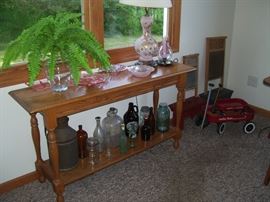 Sofa table and collectible bottles.