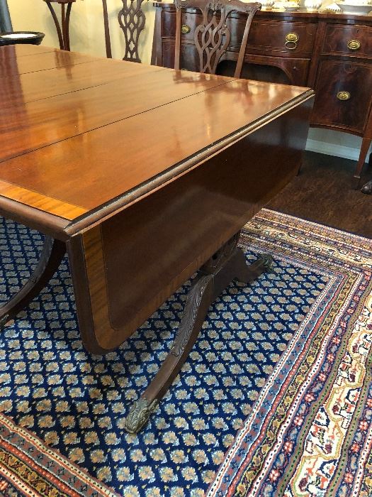 This antique circa 1900 English Regency dining table has a drop leaf feature at both ends.  It has three leaves which in place  extend it to 10 ft 10 1/2 ins in length.   It is 3 ft and 11 1/2 ins wide and 2 ft 5 ins tall with period correct brass caster wheels 