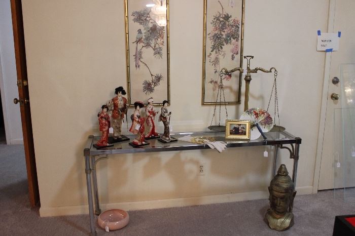 Glass and chrome foyer/console table, vintage oriental framed prints, vintage brass scale of justice and vintage Geisha girls. 
