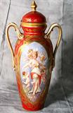 Fine Dresden porcelain ovoid form vase and cover, decorate with an oval cartouche depicting a maiden and cherubs on a red ground with gilt highlights. H: 19 1/2"