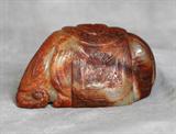 Chinese carved celadon and russet jade boulder in the form of an elephant, 19th century or earlier. The trunk curled, the body with an incised cloth over the back with edged tassels. H 2" W: 3 1/2" D: 1 7/8"