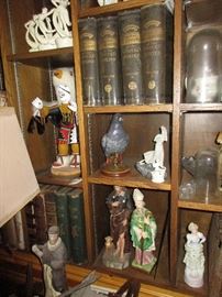 Overview of the bookcase in living room- antique books, religious figures, bird carvings, a large kachina-