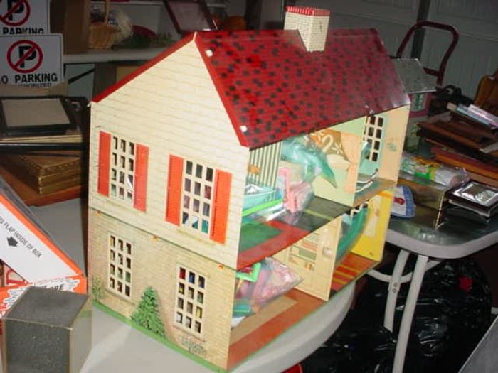 There are several 1950's metal doll houses, all complete with furniture