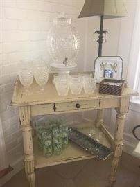 Table with plastic drinking glasses, cooler, lamp and more