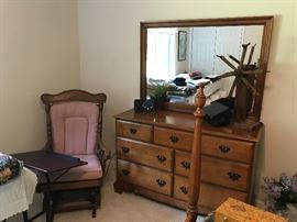 7 drawer dresser with mirror.  Platform rocker in corner.  On dresser is an antique yarn winder