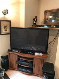 Flat screen TV and other entertainment components.  To left of TV: Kenneth Ferguson print.