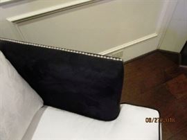 Brads detail the arms of the sofa