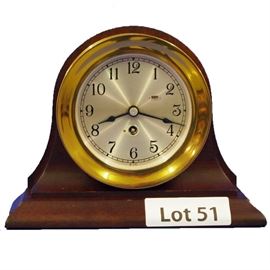Lot 51 - Mid Century Brass Ships Clock with Mahogany Stand, unmarked. 8 day time only. 6 1/2" tall.