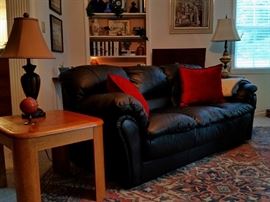 Black leather sofa by Sealy and one of two matching oak end tables