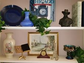 Items on these shelves include bust of John Wayne, small antique shelf clock, and Indiana carnival glass compote.