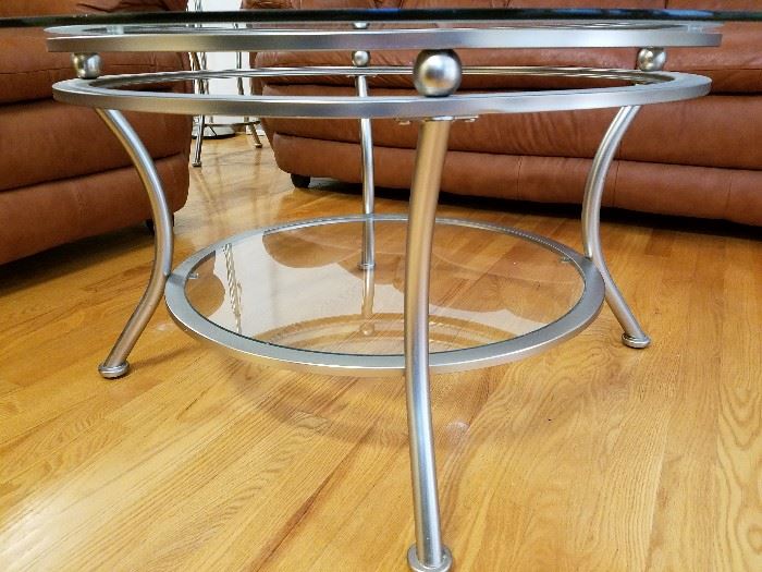 Beveled glass top, round coffee table, with bottom shelf and brushed aluminum base.  38" round, 19" tall