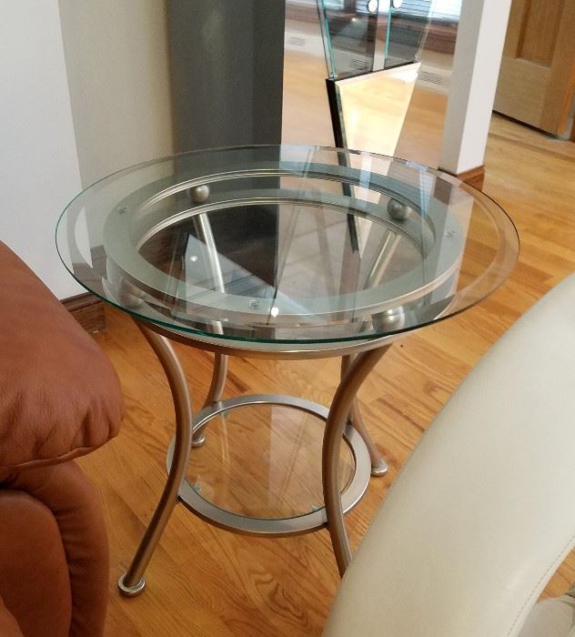 Pair of beveled glass top, round side tables, with bottom shelf and brushed aluminum bases.  24" round, 23" tall